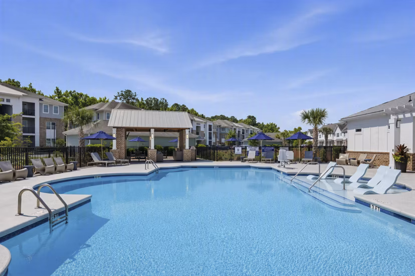 Resort-style pool at The Arden Apartments with lush landscaping and ample lounging areas