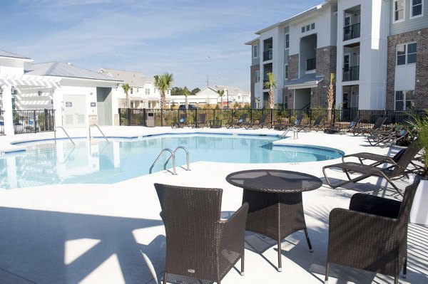 Resort-style pool at The Arden Apartments with lush landscaping and ample lounging areas