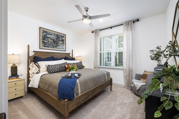 Spacious bedroom with modern decor at Album Huntersville Apartments, offering luxury living in a serene setting