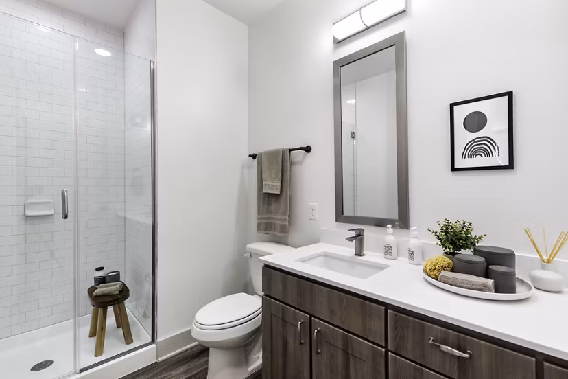 Luxurious bathroom featuring marble countertops and glass shower at The Vaughan Apartments