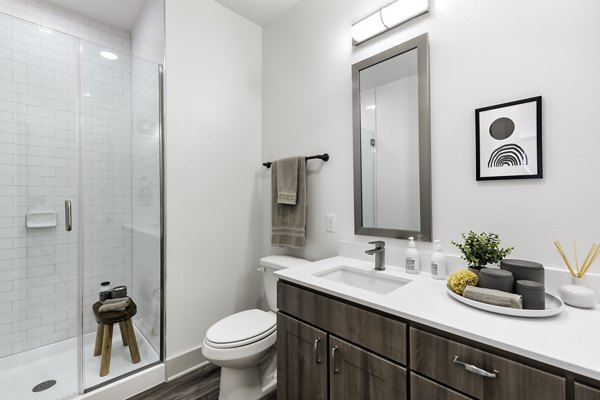 Luxurious bathroom featuring marble countertops and glass shower at The Vaughan Apartments