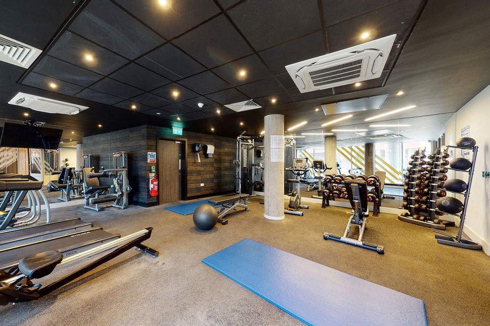 Modern gym facility at Canvas Coventry City Club in Coventry, featuring treadmills, free weights, and spacious workout areas.