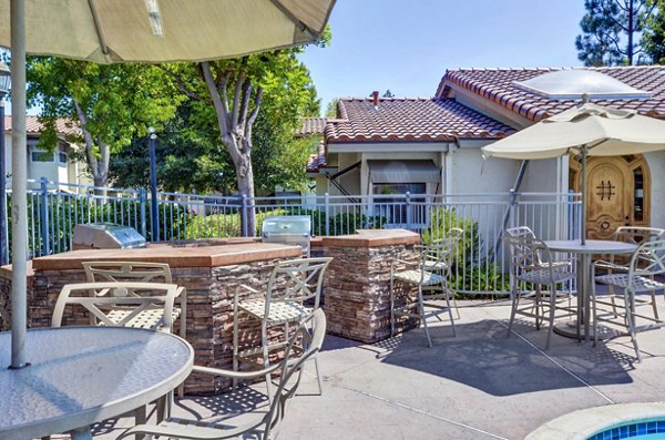 Grill area with modern seating and pergola at Adagio Apartments, ideal for outdoor gatherings and relaxation