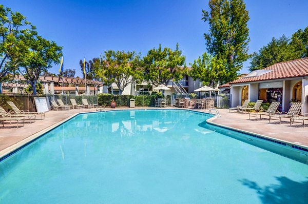 Resort-style heated pool at Adagio Apartments with luxurious lounge area and landscaped surroundings