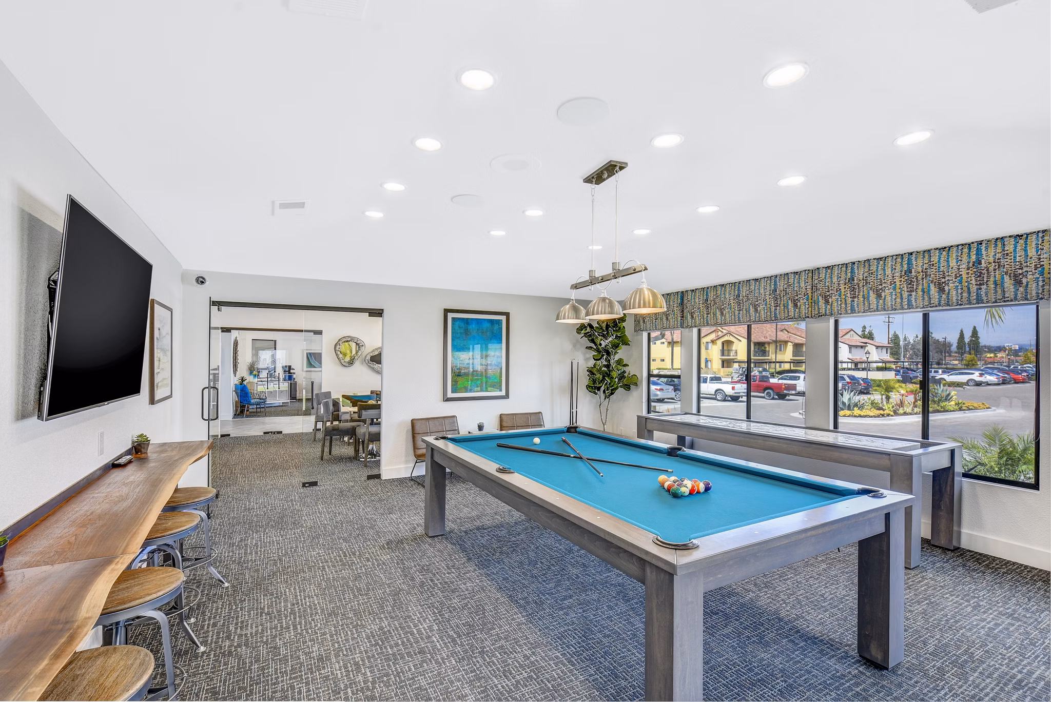 Clubhouse game room at Altair Apartments with billiards and lounge seating