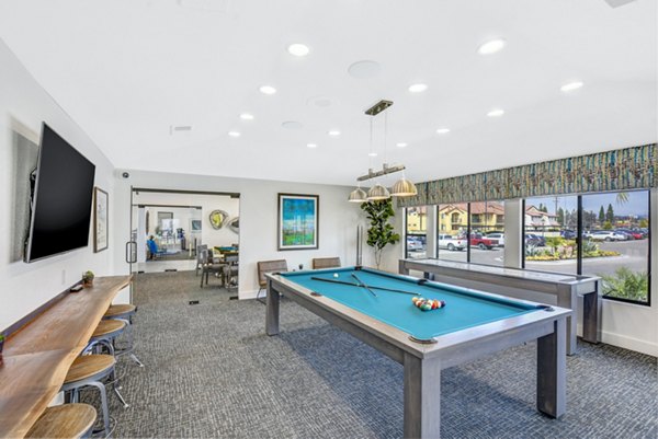 Clubhouse game room at Altair Apartments with billiards and lounge seating