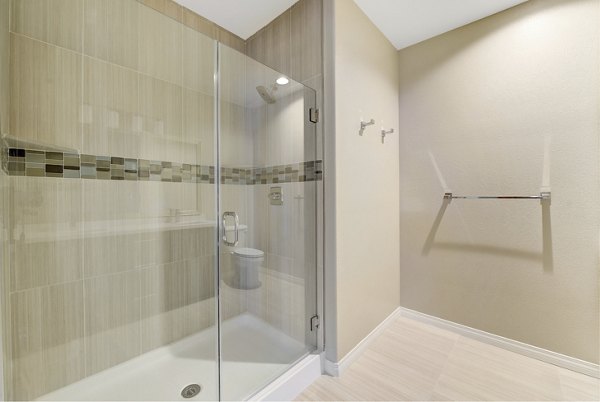 Stylish bathroom with modern fixtures at Avino Apartments, featuring elegant tile work and ample lighting, offering luxurious living spaces