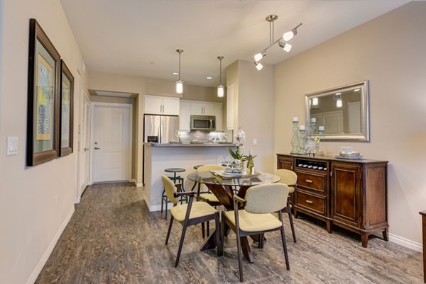 Dining area with modern furnishings and elegant lighting at Avino Apartments