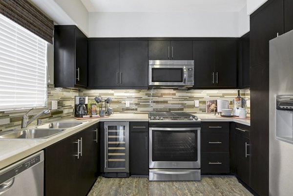 Modern kitchen with stainless steel appliances at Avino Apartments