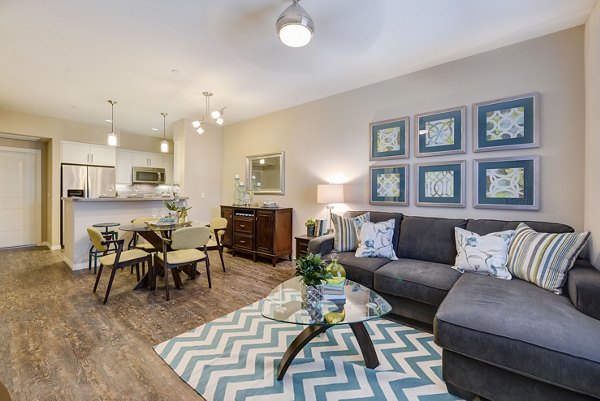Spacious living room with modern decor and large windows in Avino Apartments