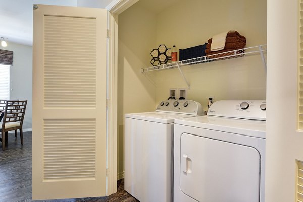 Laundry room featuring modern washers and dryers in Avino Apartments