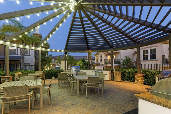 Outdoor grill area with modern seating and greenery at Avino Apartments, ideal for gatherings and relaxation