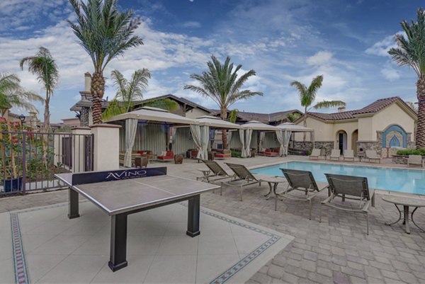 Avino Apartments: Serene courtyard with lush greenery and seating area in luxury community
