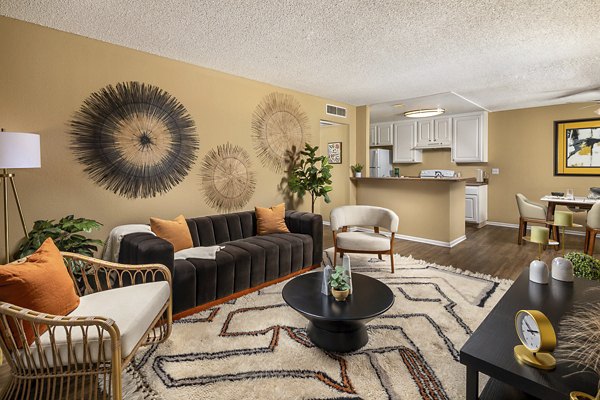 Modern living room and dining area with stylish decor featuring a black sofa and round coffee table in luxury apartments