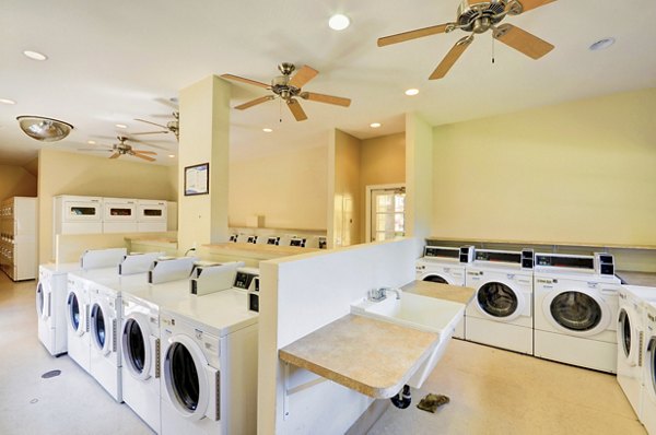 Modern laundry facility at Bella Terra Apartments with energy-efficient machines and ample folding space