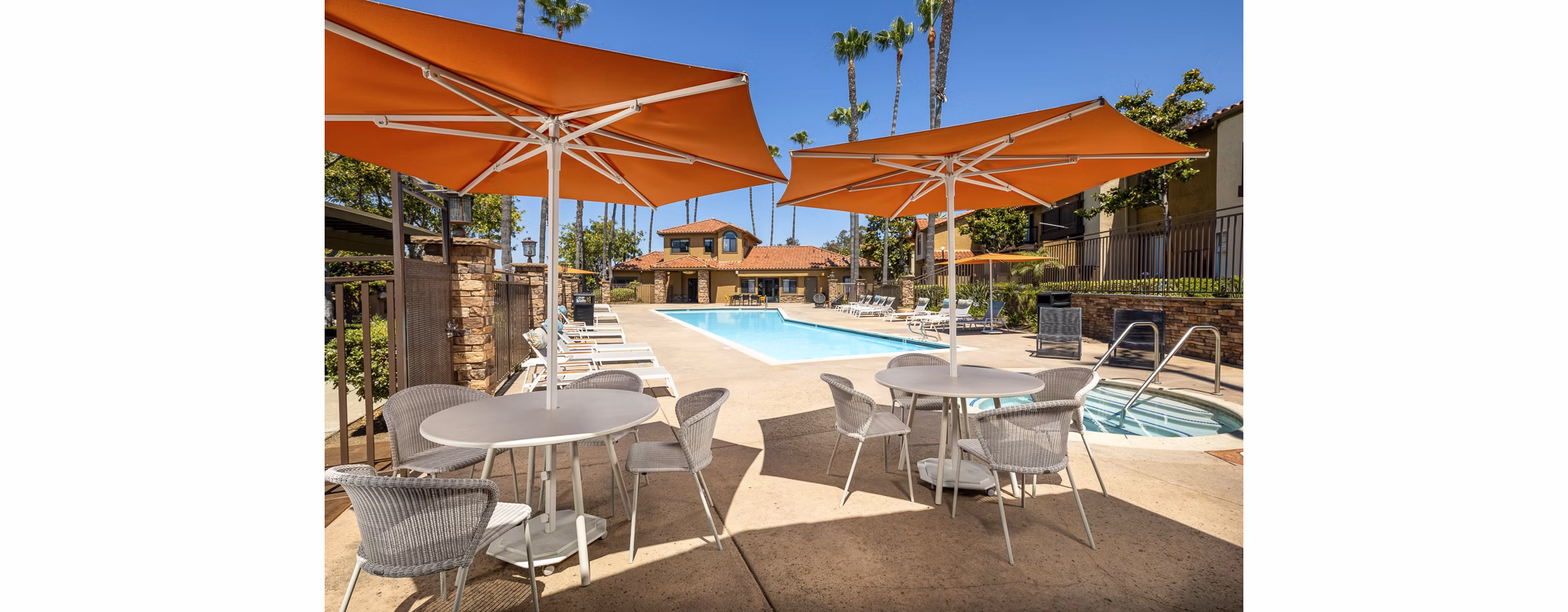 Outdoor pool with sun loungers at Bella Terra Apartments offering a relaxing retreat in a luxury residential community
