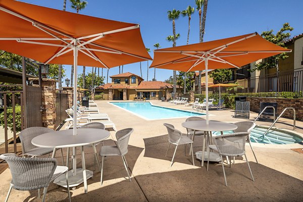 Outdoor pool with sun loungers at Bella Terra Apartments offering a relaxing retreat in a luxury residential community