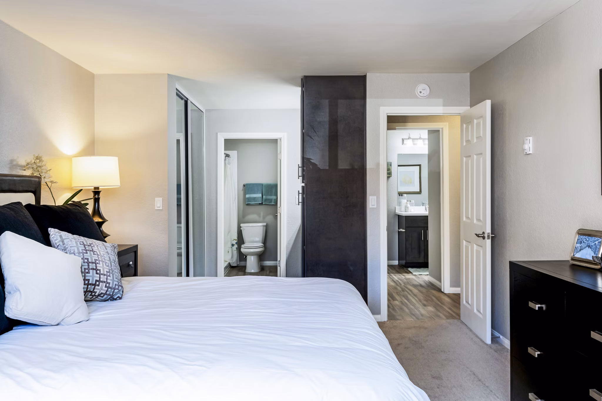 Stylish bedroom featuring modern decor and large windows at The Casas Apartments, luxury living with comfort and convenience
