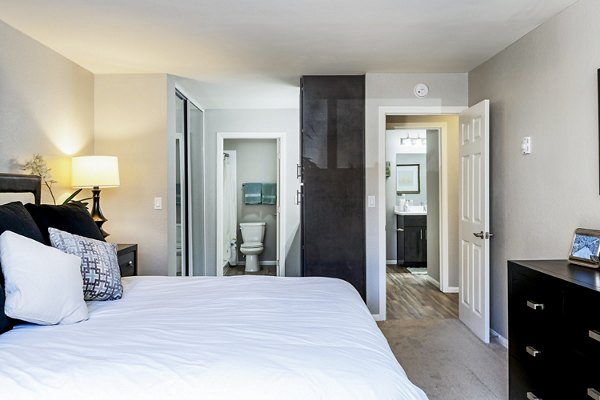 Stylish bedroom featuring modern decor and large windows at The Casas Apartments, luxury living with comfort and convenience