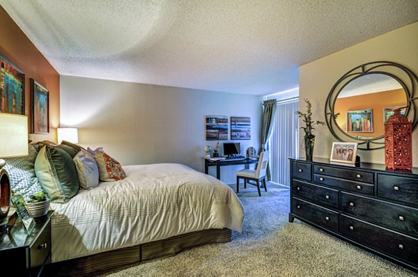 Cozy bedroom with modern decor at The Casas Apartments, featuring a plush bed and stylish furnishings for comfortable living