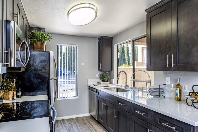 Modern kitchen with stainless steel appliances and island at The Casas Apartments