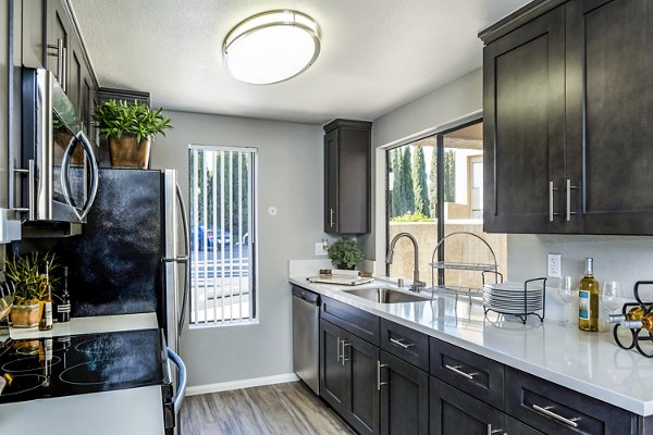 Modern kitchen with stainless steel appliances and island at The Casas Apartments