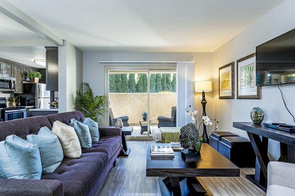 Modern living room with plush seating and natural light at The Casas Apartments in a luxury Greystar community