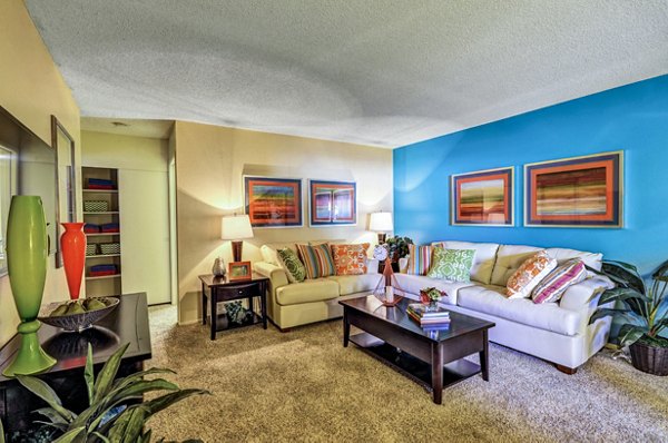 Elegant living room with modern decor and large windows at The Casas Apartments