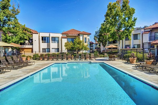 Resort-style pool area with sun loungers at The Casas Apartments, ideal for relaxation and leisure