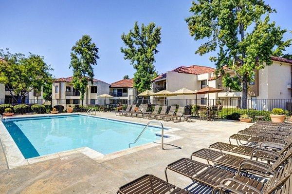Resort-style pool with loungers at The Casas Apartments offers luxurious relaxation in a sophisticated setting