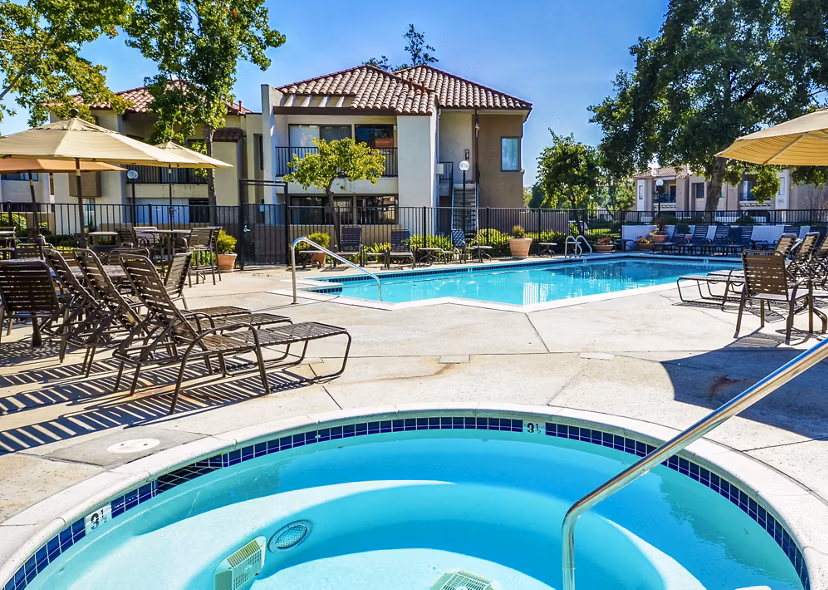 Relaxing poolside with hot tub at The Casas Apartments, a luxury community by Greystar