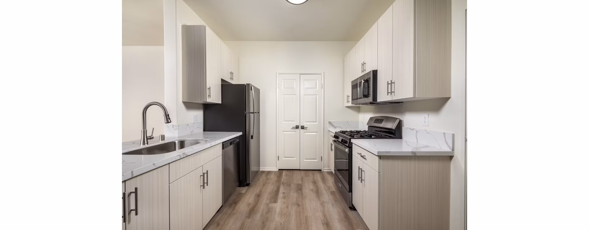 Modern kitchen featuring stainless steel appliances and granite countertops at Casoleil Apartments