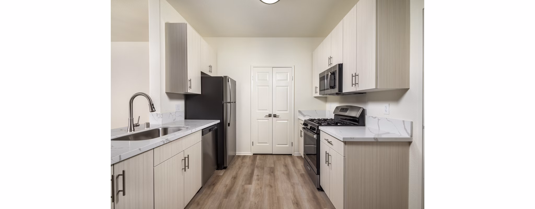 Modern kitchen featuring stainless steel appliances and granite countertops at Casoleil Apartments