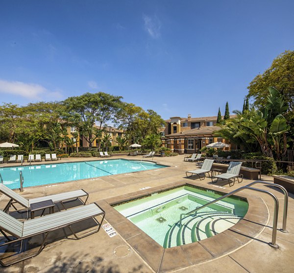 Resort-style pool with lounging chairs at Casoleil Apartments in vibrant luxury community