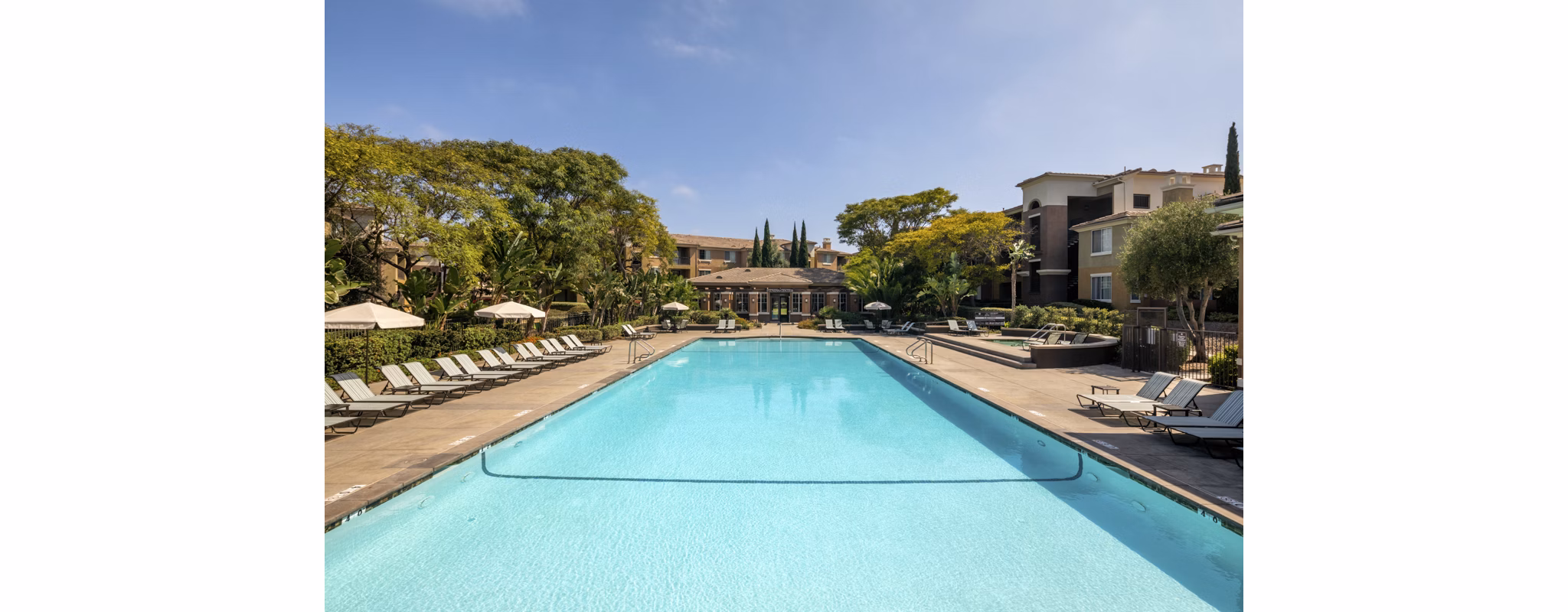 Expansive swimming pool area with lounge chairs at Casoleil Apartments, offering luxury outdoor relaxation