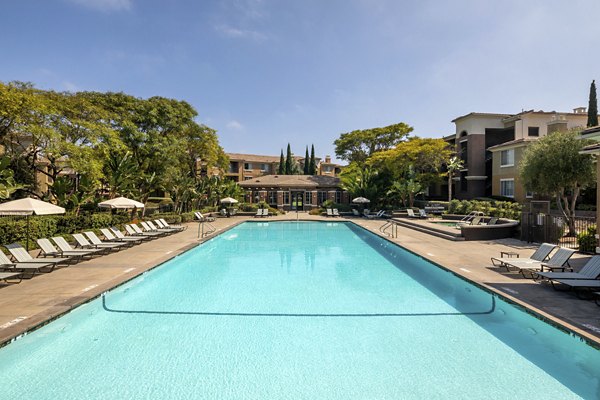 Expansive swimming pool area with lounge chairs at Casoleil Apartments, offering luxury outdoor relaxation
