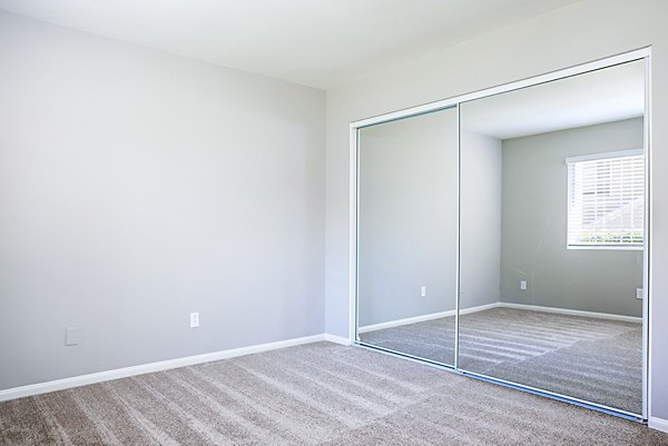 Cozy bedroom with modern decor in Central Park Apartments, featuring plush bedding and ample natural light