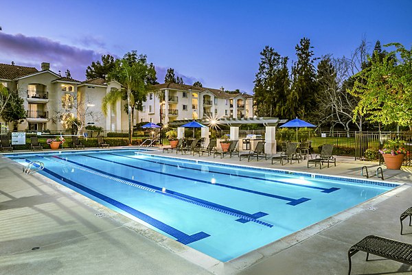 Modern outdoor pool at Central Park Apartments with sun loungers and skyline views