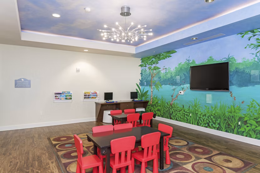 Game room with pool table and lounge seating at Greenfield Village Apartments