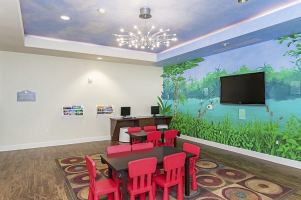 Game room with pool table and lounge seating at Greenfield Village Apartments