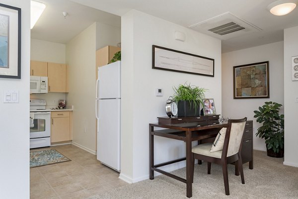 Cozy living room with modern decor and large windows at Greenfield Village Apartments