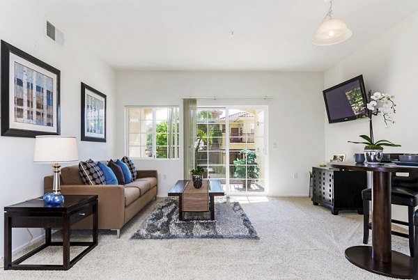 Spacious living room featuring modern decor and large windows at Greenfield Village Apartments, offering luxury living in a tranquil setting
