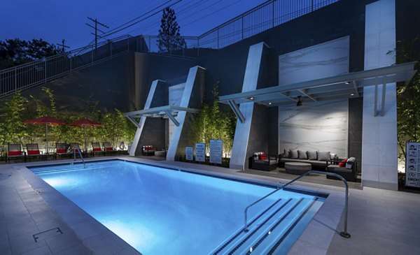 Infinity pool with sun loungers at Hanover West LA Apartments offering a luxury living experience in Los Angeles