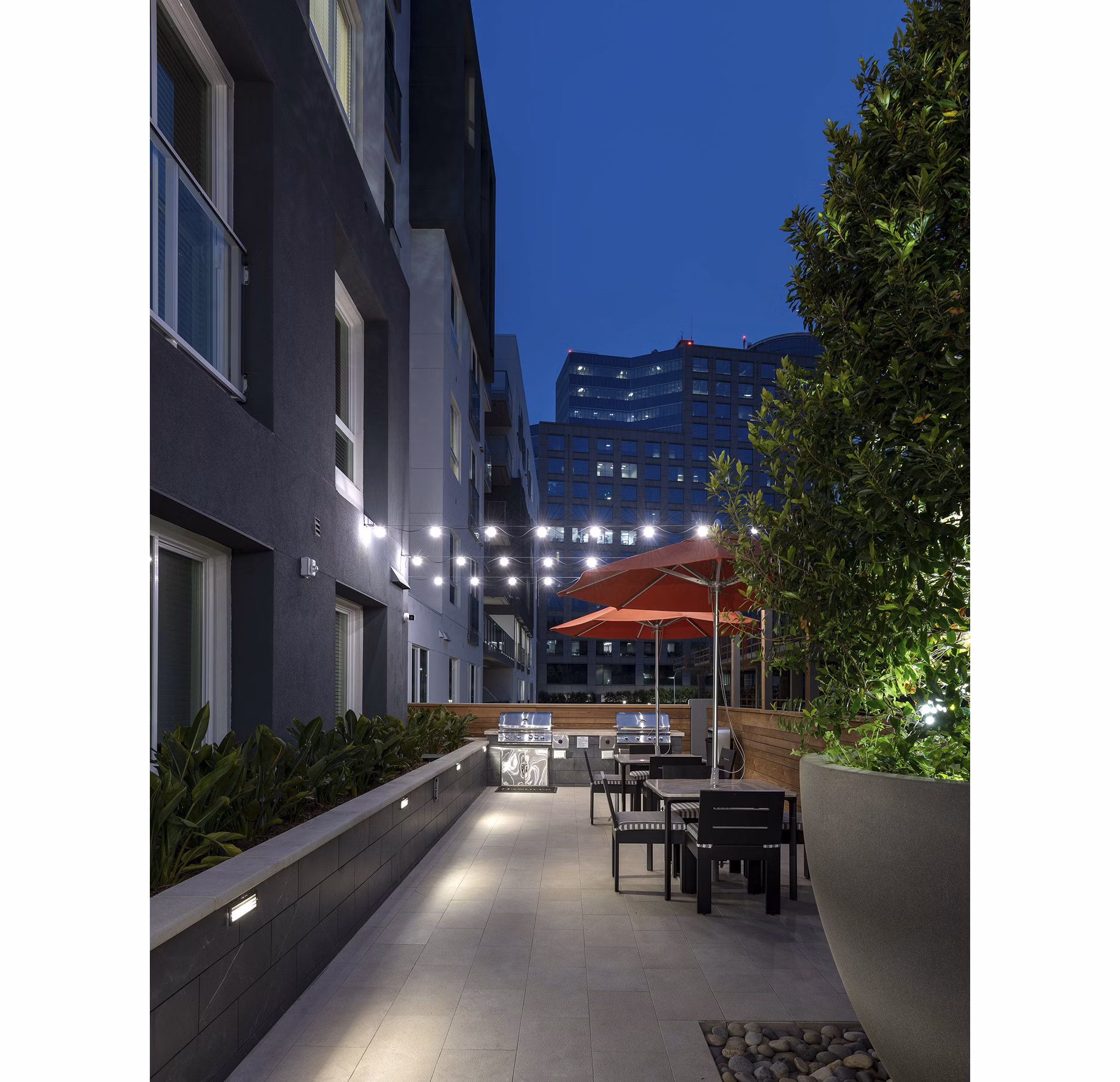 Grill area with outdoor seating at Hanover West LA Apartments for social gatherings and relaxation