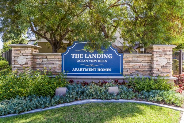 The Landing Ocean View Hills Apartment Homes sign with lush landscaping in front of the entrance