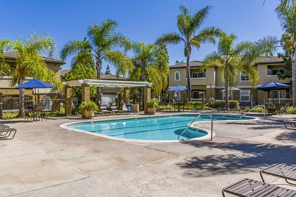 The Landing at Ocean View Hills Apartments: Modern outdoor pool area with palm trees and lounge chairs