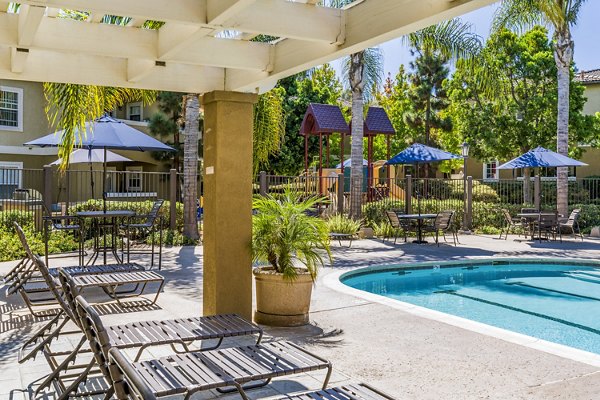 Outdoor pool patio with loungers at The Landing at Ocean View Hills Apartments, perfect for relaxation in a luxury setting