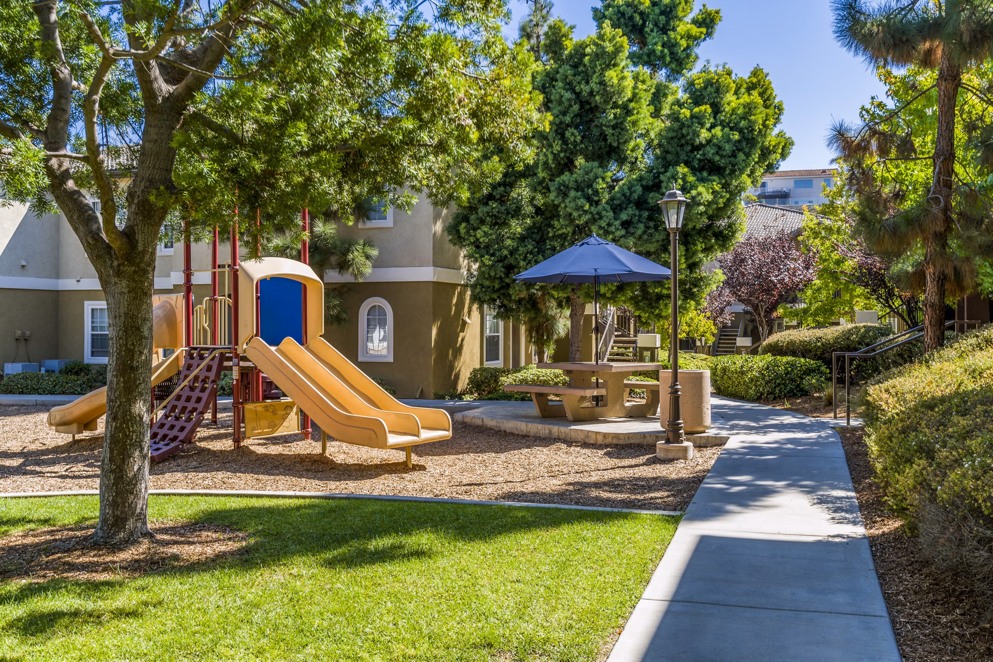 Playground with vibrant play structures at The Landing at Ocean View Hills Apartments, ideal for family-friendly activities and outdoor fun