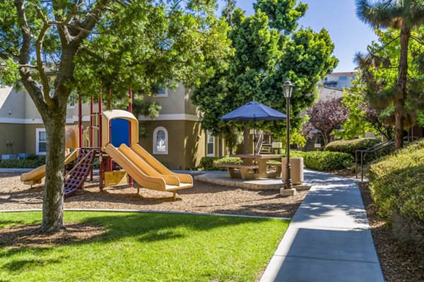 Playground with vibrant play structures at The Landing at Ocean View Hills Apartments, ideal for family-friendly activities and outdoor fun