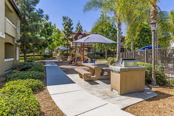 Family-friendly playground and grill area at The Landing at Ocean View Hills Apartments